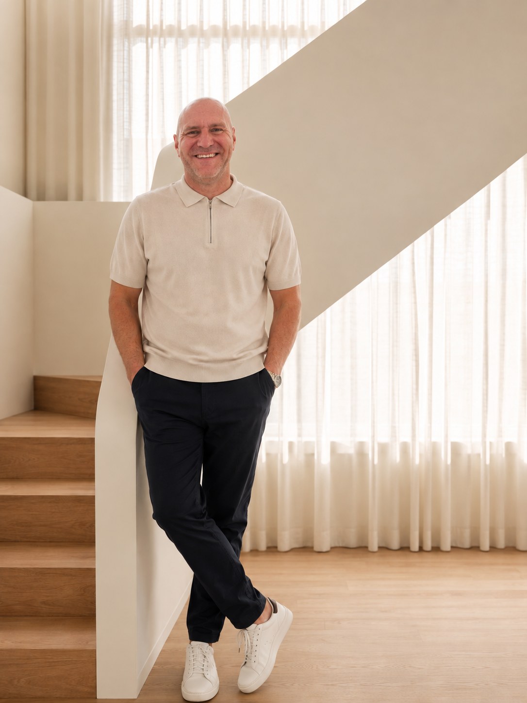 Steve Holland standing beside a staircase and full-height sheer curtains